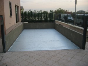 Elevatore per auto a comando elettrico con movimentazioni oleodinamiche per traslazione di autovetture tra piani definiti a pantografo con coperchio di chiusura fossa