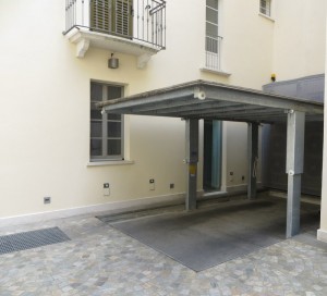 Elevatore per auto a comando elettrico con movimentazioni oleodinamiche per traslazione di autovetture tra piani definiti a pantografo con coperchio di chiusura fossa