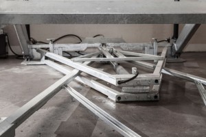 Elevatore per auto a comando elettrico con movimentazioni oleodinamiche per traslazione di autovetture tra piani definiti a pantografo senza coperchio di chiusura fossa