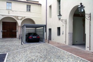 Elevatore per auto a comando elettrico con movimentazioni oleodinamiche per traslazione di autovetture tra piani definiti a pantografo con coperchio di chiusura fossa