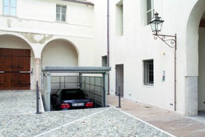 Elevatore per auto a comando elettrico con movimentazioni oleodinamiche per traslazione di autovetture tra piani definiti a pantografo con coperchio di chiusura fossa